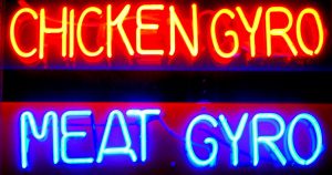 a neon sign the reads 'chicken gyro, meat gyro'