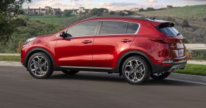 2020 Kia Sportage in red driving down a semi country road 